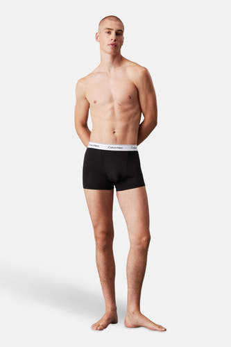 Sous-vêtement noir de Calvin Klein porté par un homme avec les mains sur le dos.