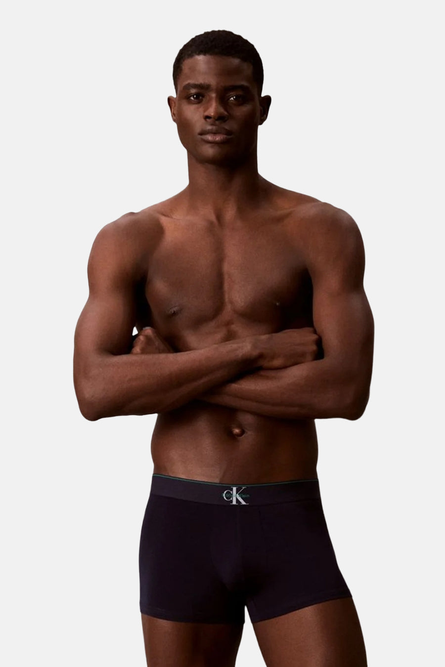 Zwarte boxershort van Calvin Klein, gedragen door een man met gekruiste armen.