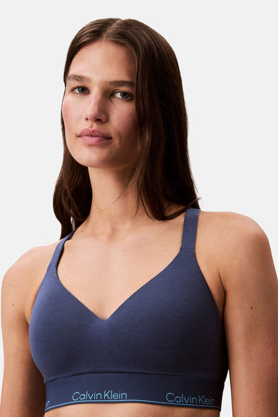 Vrouw draagt blauwe Calvin Klein sportbeha.