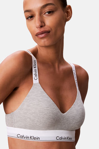 Grijze beha van Calvin Klein, met witte bandjes en een witte elastische boord onder de buste.
