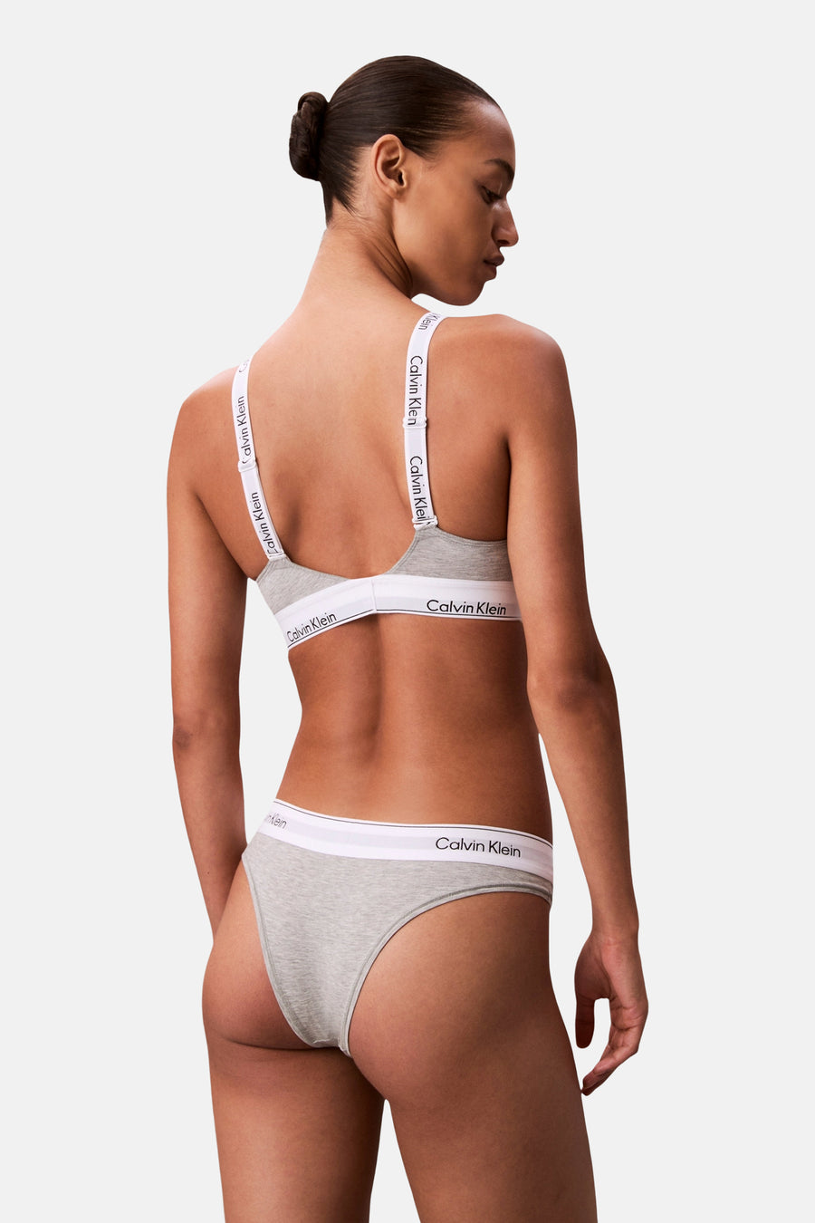 Grijze beha van Calvin Klein, met witte bandjes met logo, achterkant gezien.