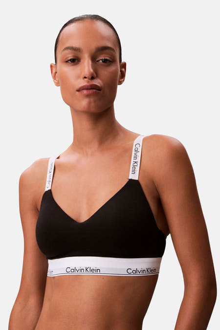 Zwarte beha van Calvin Klein met witte bandjes met logo, op een model.
