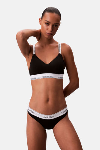 Zwarte beha van Calvin Klein, gedragen door een model met bijpassende onderbroek tegen een effen achtergrond.
