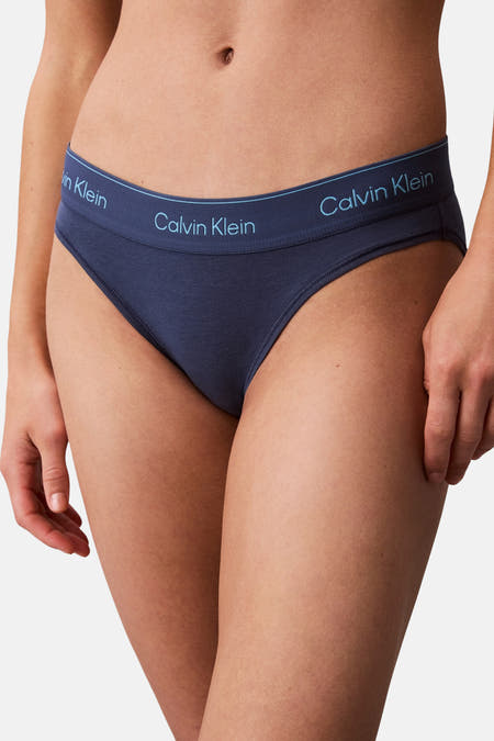 Jean bleu de Calvin Klein, avec une ceinture élastique et des détails de logo.