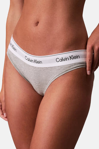 Grijze slip van Calvin Klein met een witte elastische band met logo, close-up.
