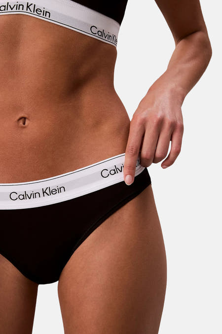 Zwarte slip van Calvin Klein, met een witte tailleband met logo, gedragen door een model.
