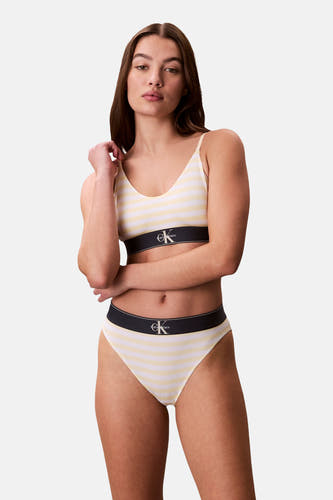 Gele slip van Calvin Klein, met een gestreept patroon en een zwarte elastische band.
