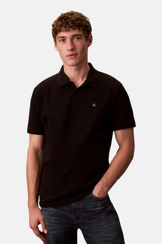 Zwarte polo met korte mouwen van Calvin Klein, gedragen met een donkere jeans.