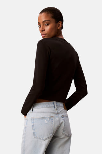 T-shirt noir à manches longues de Calvin Klein, vu de l'arrière, associé à des jeans bleu clair.