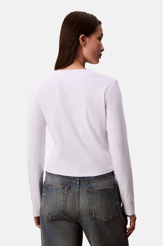 T-shirt blanc à longues manches de Calvin Klein, texture côtelée, associé à un pantalon en denim, vue arrière.