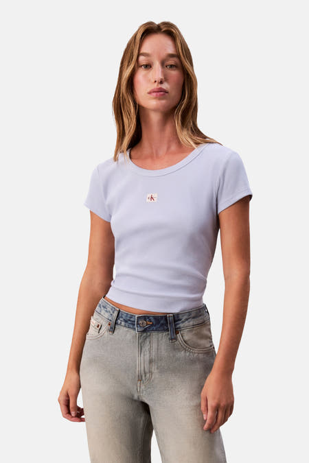 T-shirt bleu à manches courtes de Calvin Klein, porté avec un blouson et des pantalons en denim.