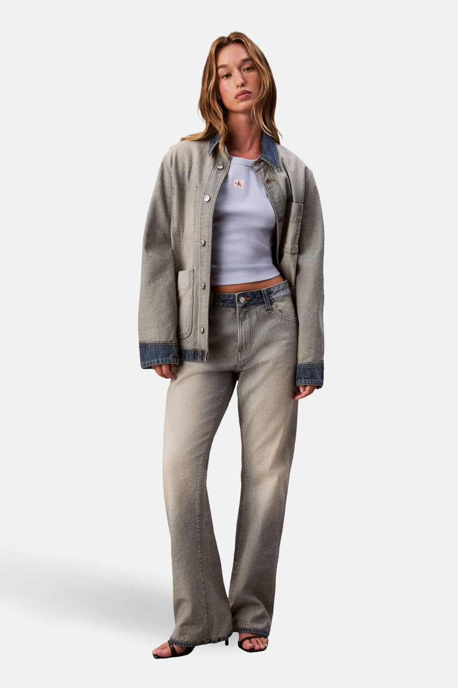 Blauw T-shirt met korte mouwen van Calvin Klein, gedragen met een denim jack en broek.
