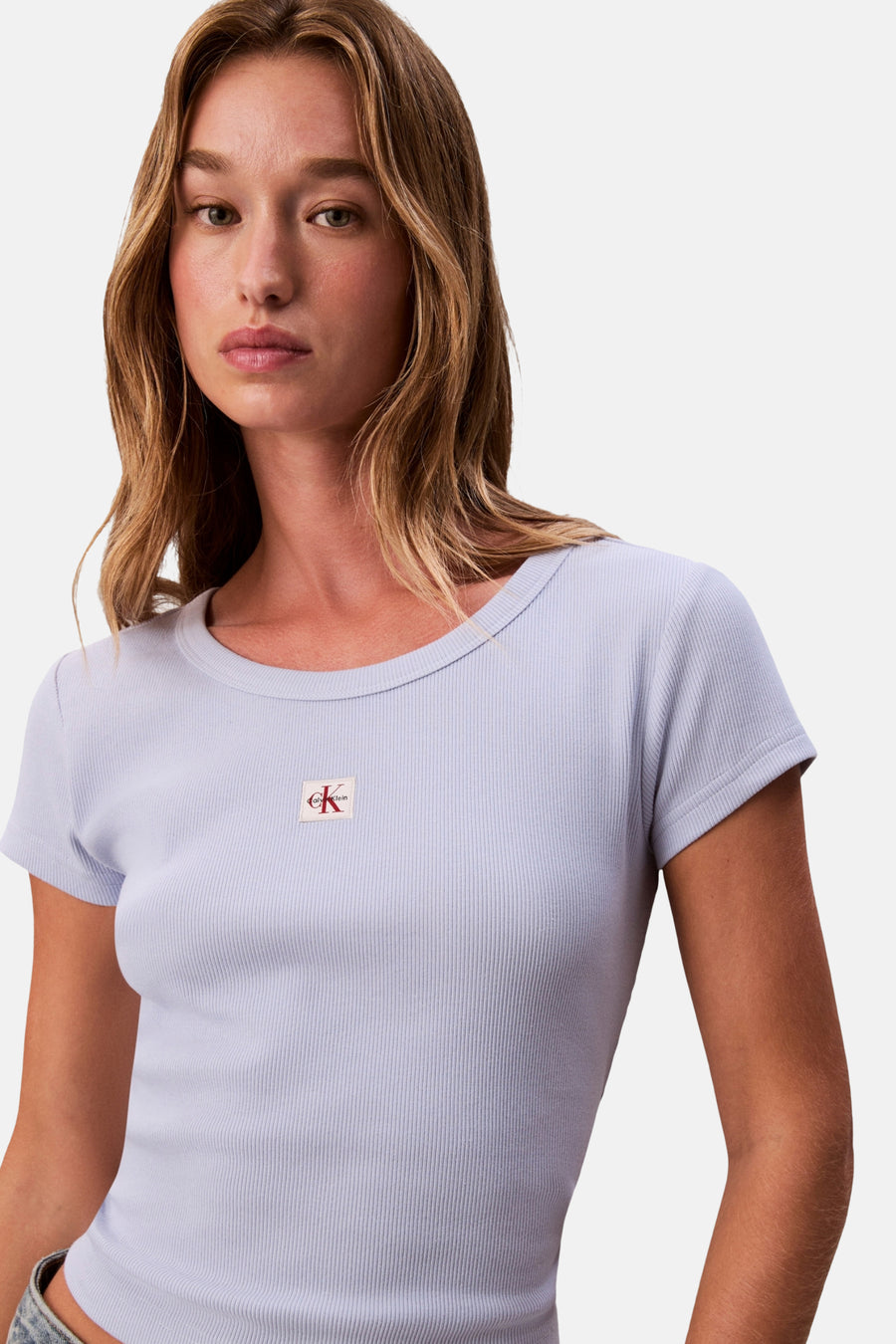 Vrouw in een blauw Calvin Klein geribbeld shirt.