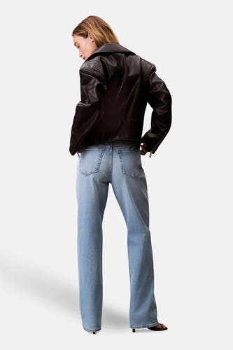 Jeans straight lichtblauwe denim van Calvin Klein, achterkant, gecombineerd met een zwarte leren jas.