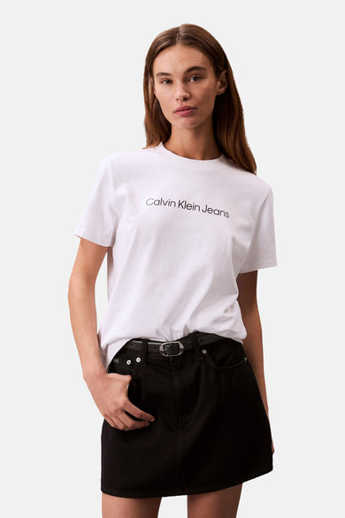 Wit T-shirt met korte mouwen van Calvin Klein Jeans, gedragen met een zwarte rok met riem.
