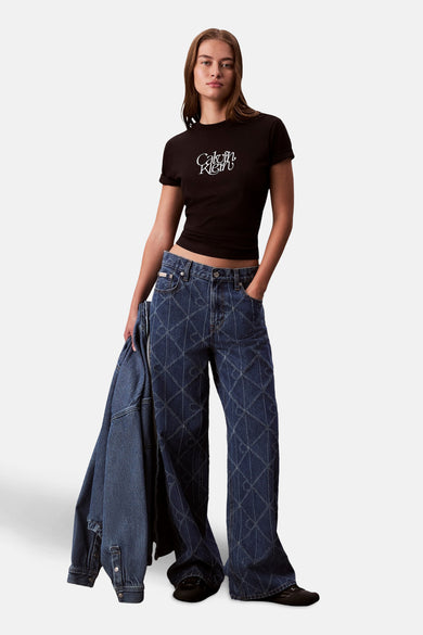 T-shirt noir à manches courtes de Calvin Klein, avec un logo blanc sur la poitrine, associé à des jeans à carreaux.