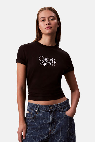 T-shirt noir à manches courtes de Calvin Klein, porté avec un jean bleu imprimé.