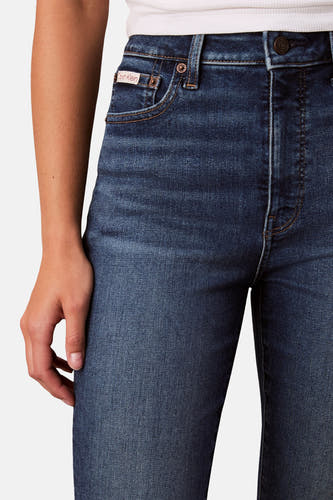 Jean skinny en denim bleu moyen de Calvin Klein, avec des coutures visibles et un subtil logo de marque sur la poche.
