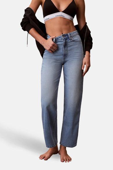 Jeans coupe spéciale en denim bleu clair de Calvin Klein, avec un mannequin dans un haut et une veste noirs, debout.