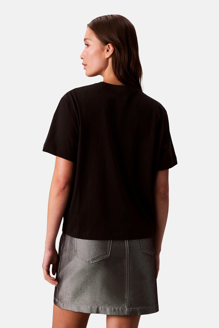 T-shirt noir à manches courtes de Calvin Klein, vu de l'arrière, associé à une jupe argentée.
