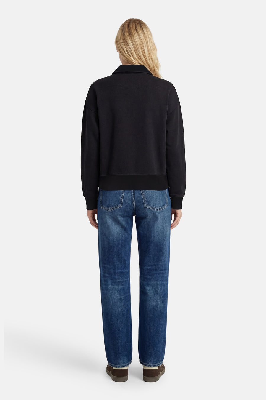 Pull noir de Calvin Klein, à longues manches, porté avec des jeans et des chaussures marrons, vu de dos.