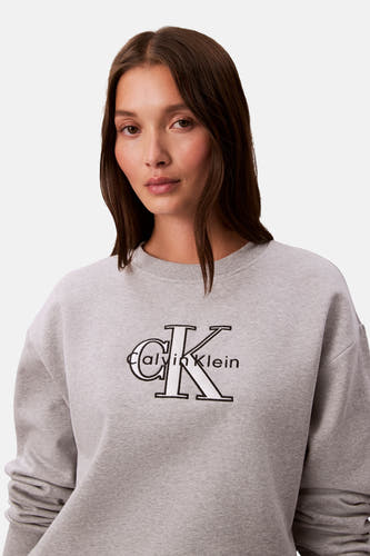 Grijze sweater van Calvin Klein, met een groot CK-logo op de borst.