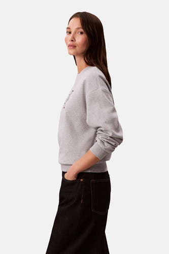 Grijze sweater met ronde hals van Calvin Klein, met zwarte jeans.