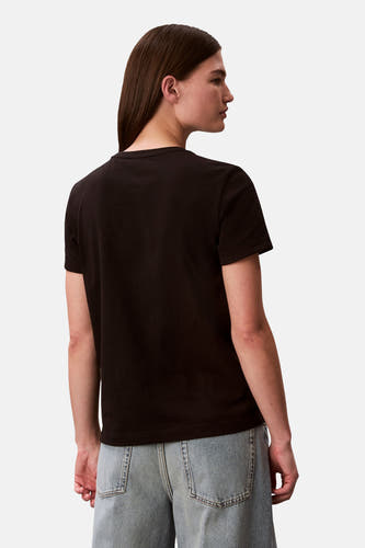 Zwart T-shirt van Calvin Klein, achterkant gezien, gecombineerd met een spijkerbroek.
