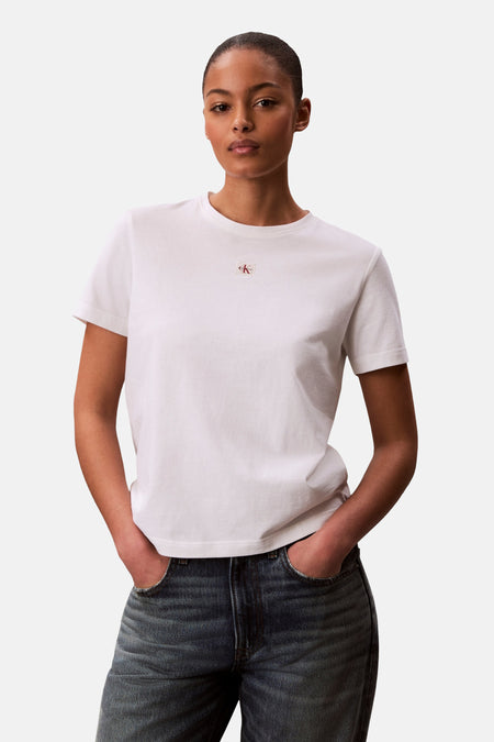 T-shirt blanc Calvin Klein, à manches courtes et avec un petit logo sur la poitrine, porté avec un jean foncé.