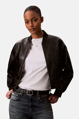 Wit T-shirt van Calvin Klein, gedragen onder een zwart leren bomberjack met een zilveren ritssluiting.