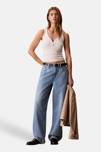 Lichtblauwe denim jeans met speciale pasvorm van Calvin Klein, gedragen door een model met een wit hemdje en zwarte riem.