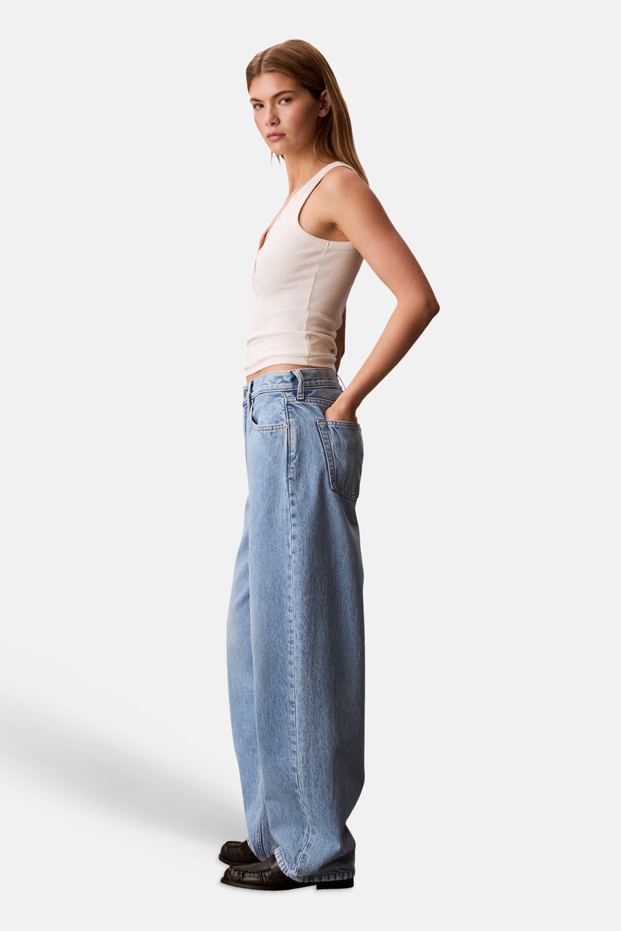 Lichtblauwe denim jeans met speciale pasvorm van Calvin Klein, met wijde pijpen, gedragen door een model met handen in zakken.
