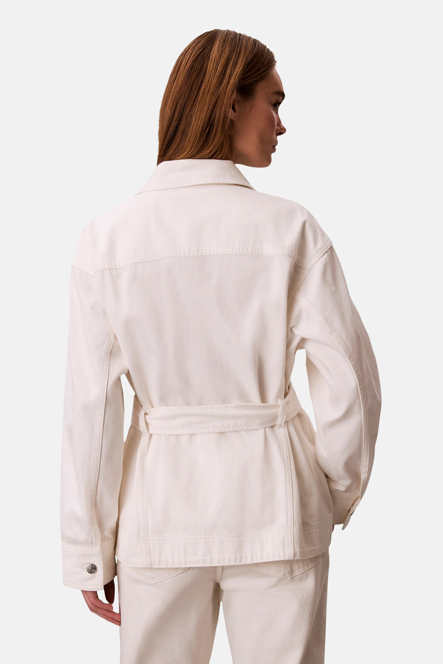 Veste courte en jean blanc cassé de Calvin Klein, avec ceinture et manches longues, vue de dos.