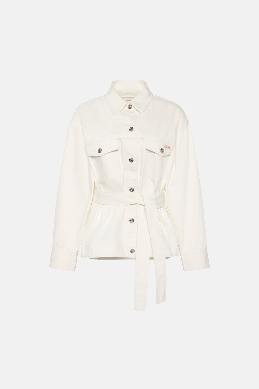 Veste courte en denim blanc cassé de Calvin Klein, avec une ceinture et des boutons argentés.