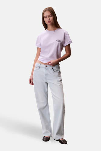 Paars T-shirt met korte mouwen van Calvin Klein, met een klein logo en gedragen met lichtblauwe jeans.