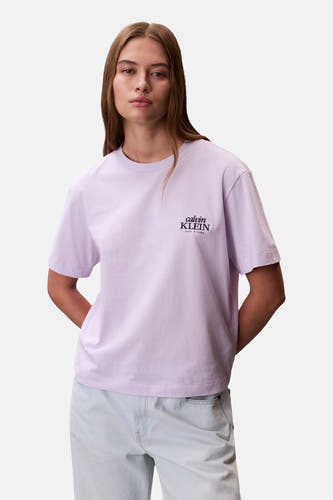 Paars T-shirt met korte mouwen van Calvin Klein, met klein logo op de borst en gedragen met een lichtblauwe jeans.
