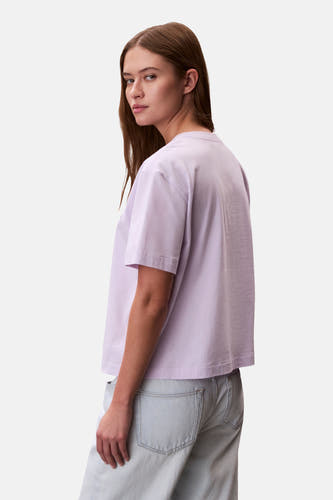 Paars T-shirt met korte mouwen van Calvin Klein, losse pasvorm, gecombineerd met een lichtblauwe jeans.