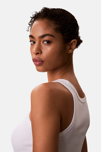 Witte top van Calvin Klein, gezien over de schouder met een geribbelde textuur en een witte tanktop.