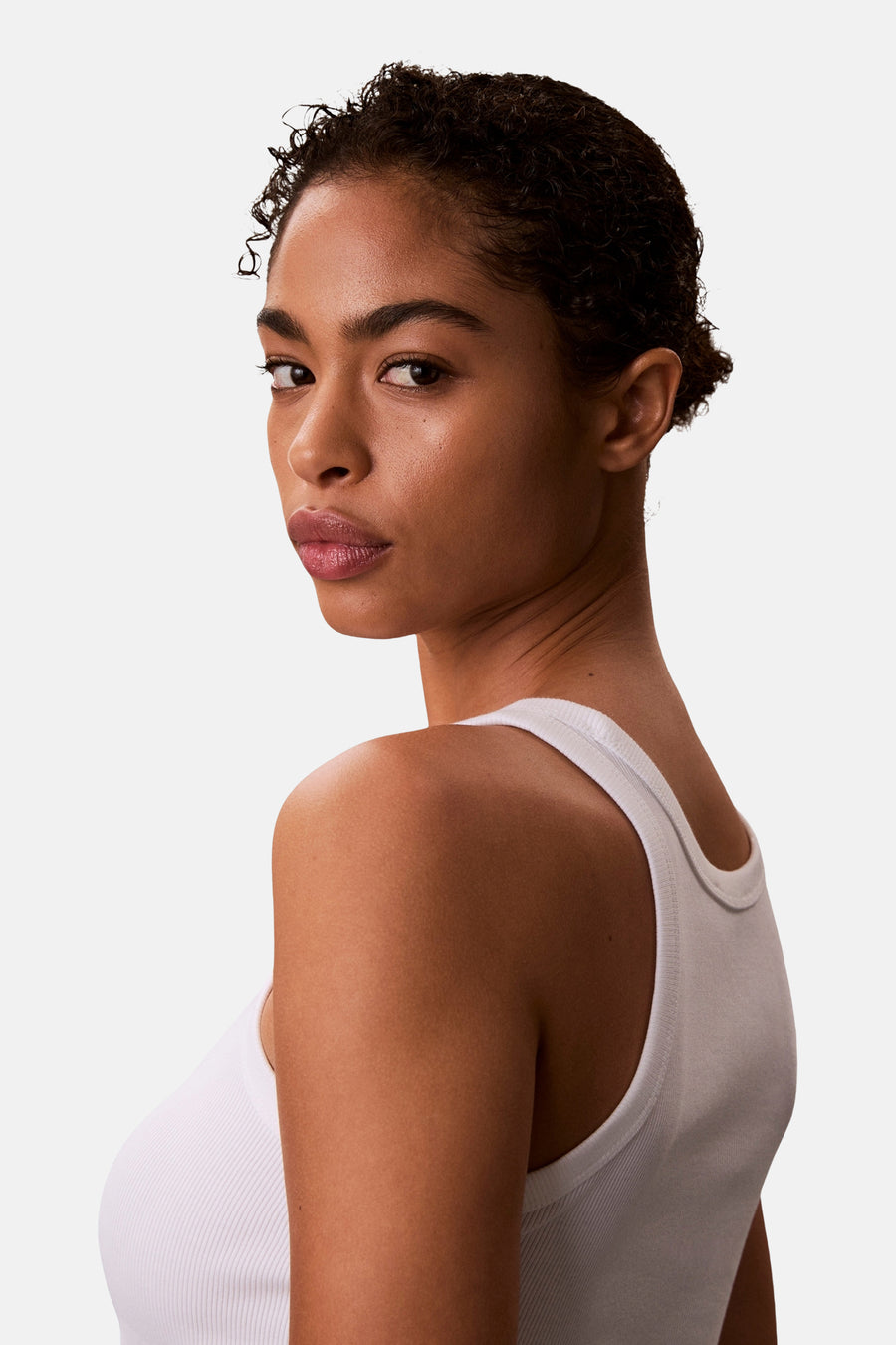 Witte top van Calvin Klein, gezien over de schouder met een geribbelde textuur en een witte tanktop.