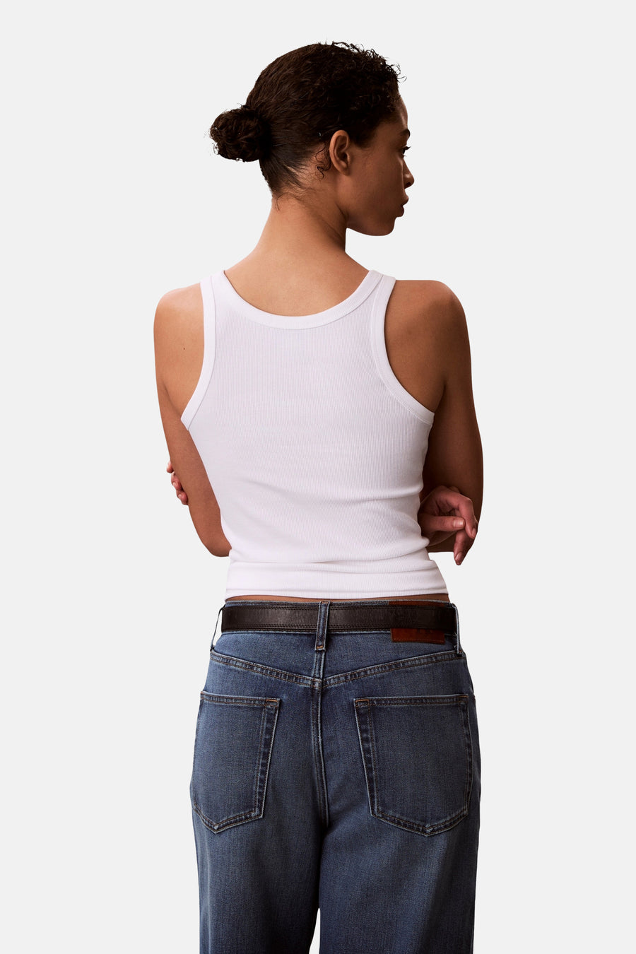 Witte top van Calvin Klein, gezien van achteren met een ribgebreide textuur en gecombineerd met een jeans en riem.