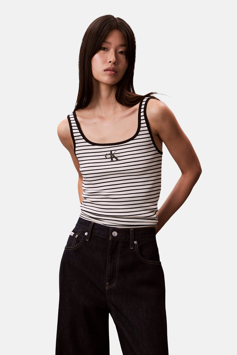 Veelkleurige singlet van Calvin Klein, met een gestreept patroon, gecombineerd met donkere jeans.
