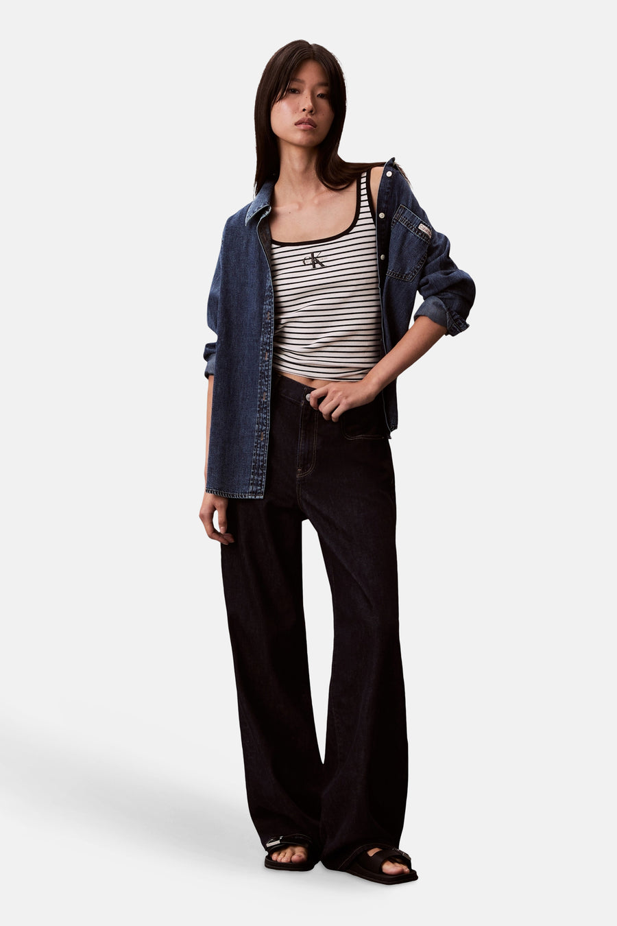 Mouwtap top met strepen van Calvin Klein, gedragen met een jeans overhemd en wijde, donkere jeans.