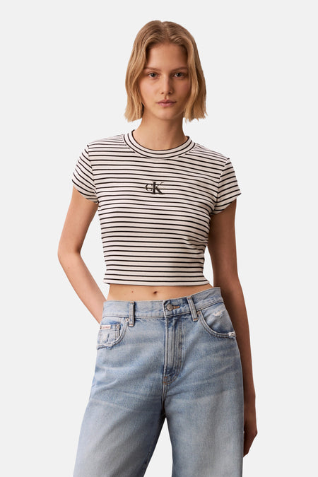 Multikleurig T-shirt van Calvin Klein, met korte mouwen en een gestreept patroon, gecombineerd met een blauwe jeans.
