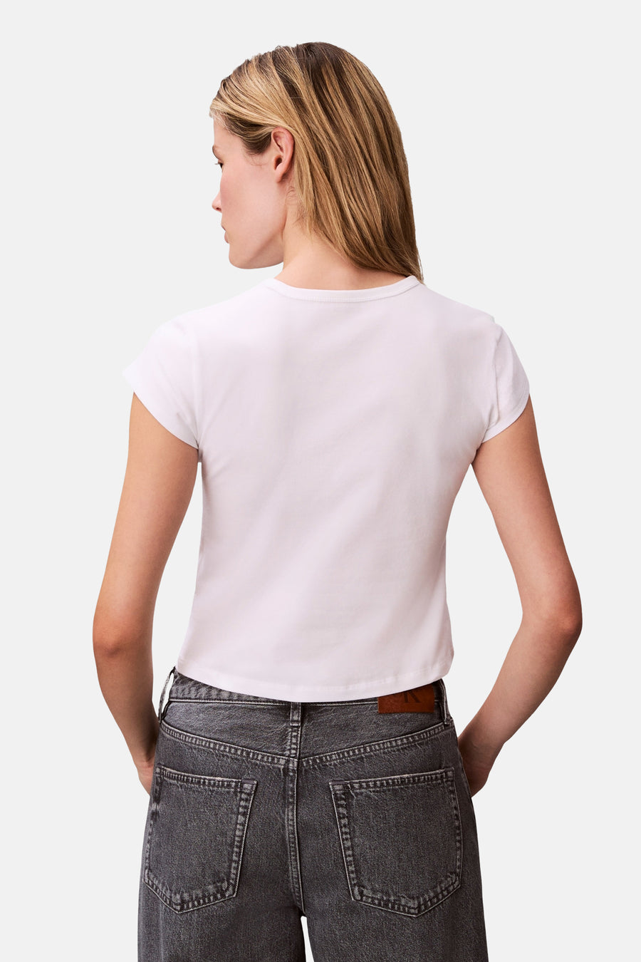 T-shirt blanc à manches courtes Calvin Klein, vu de dos, associé à un jean gris.