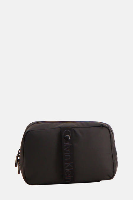 Zwarte toilettas van Calvin Klein met een stoffen band met logo.
