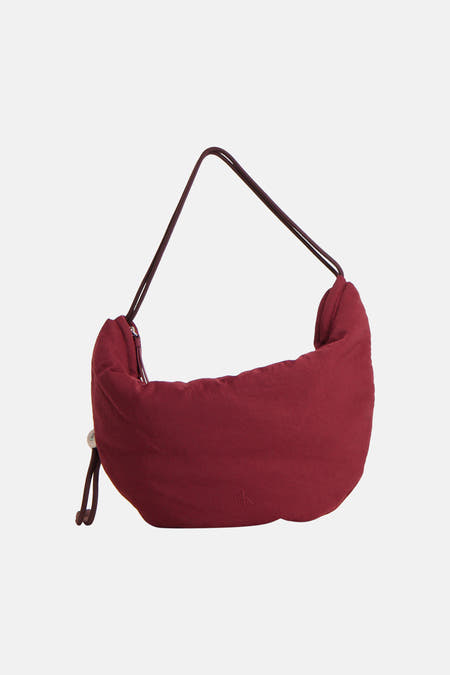Bordeaux schoudertas van Calvin Klein, met een gladde stof en een subtiel CK-logo aan de voorkant.
