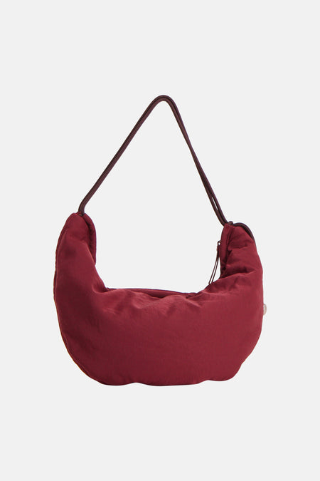 Bordeaux schoudertas van Calvin Klein, met een gladde textuur en een donkerbruine schouderband.