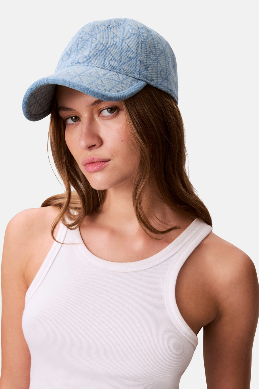 Chapeau bleu de Calvin Klein avec un motif subtil, porté par un modèle en t-shirt blanc.