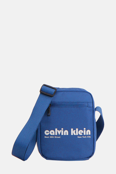 Sac à dos bleu de Calvin Klein, avec logo blanc et sangle d'épaule ajustable.