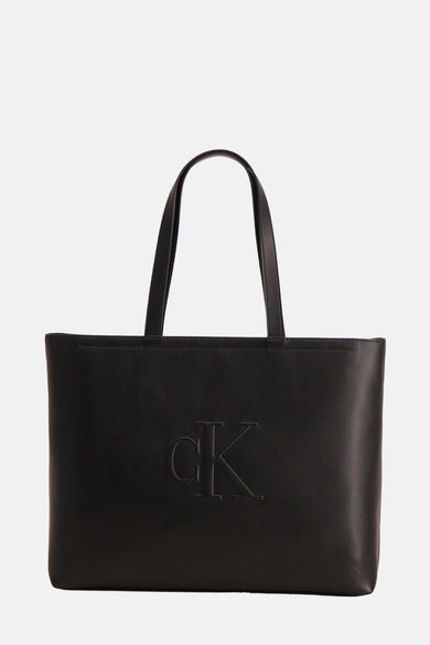 Sac à main noir de Calvin Klein avec un logo CK en relief sur l'avant.